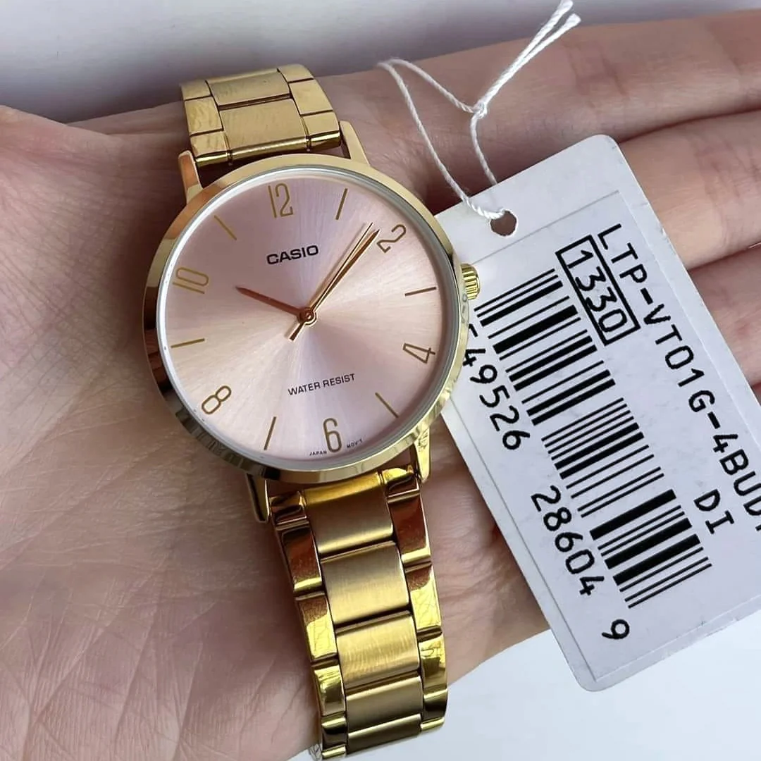 Close-up of pink dial with slim hands and hour markers