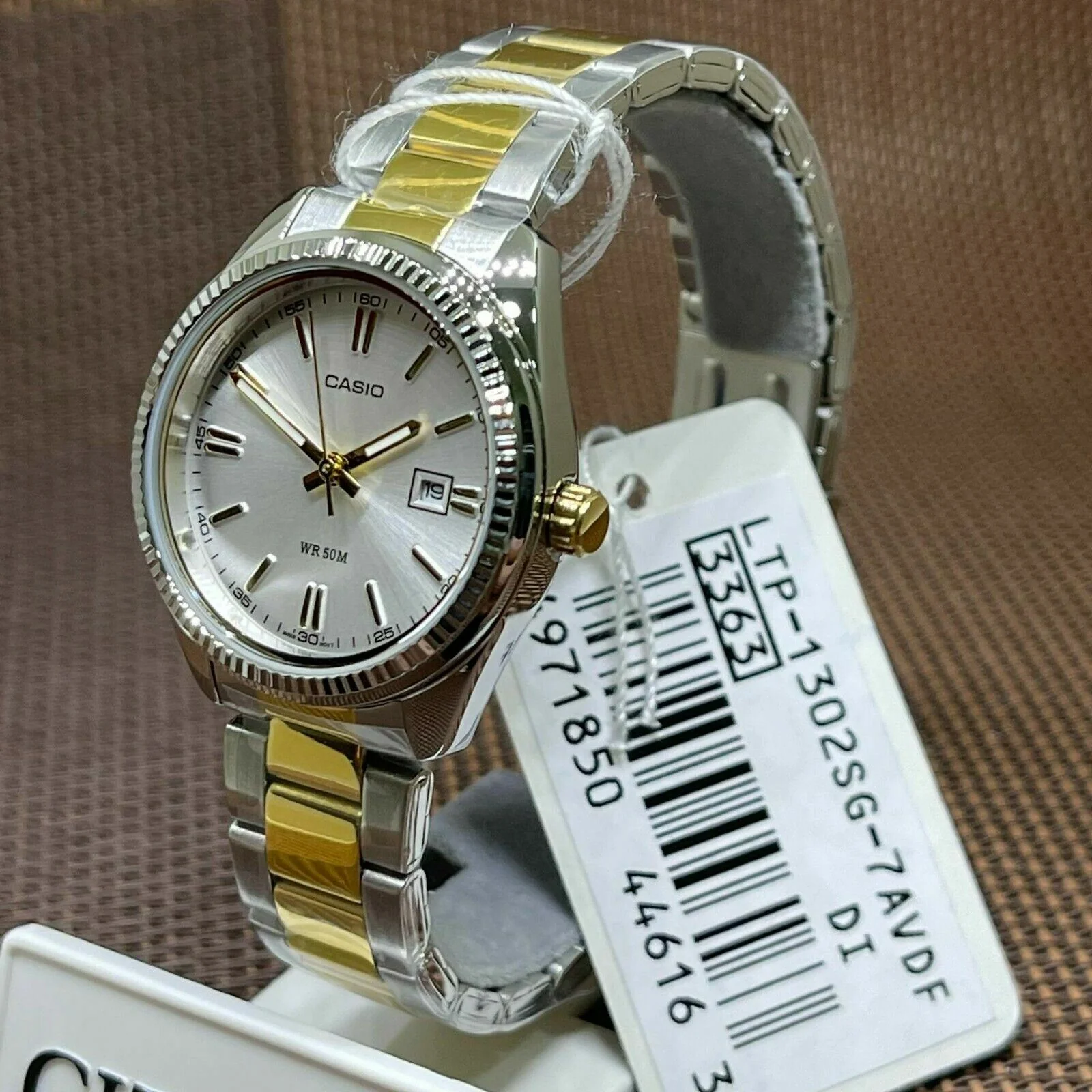 Close-up of white dial with date window and gold-tone hands