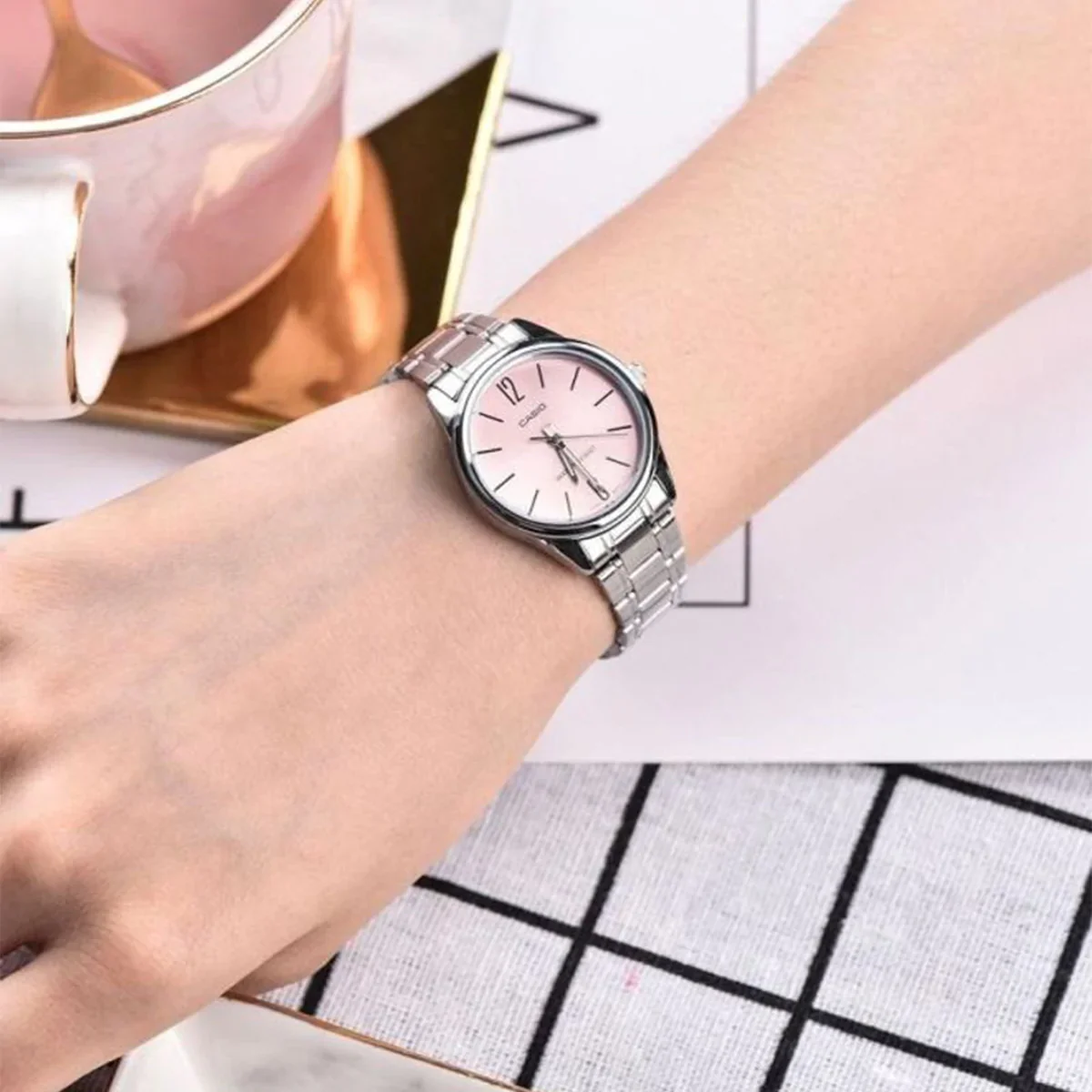 Close-up of pink dial and polished silver bracelet