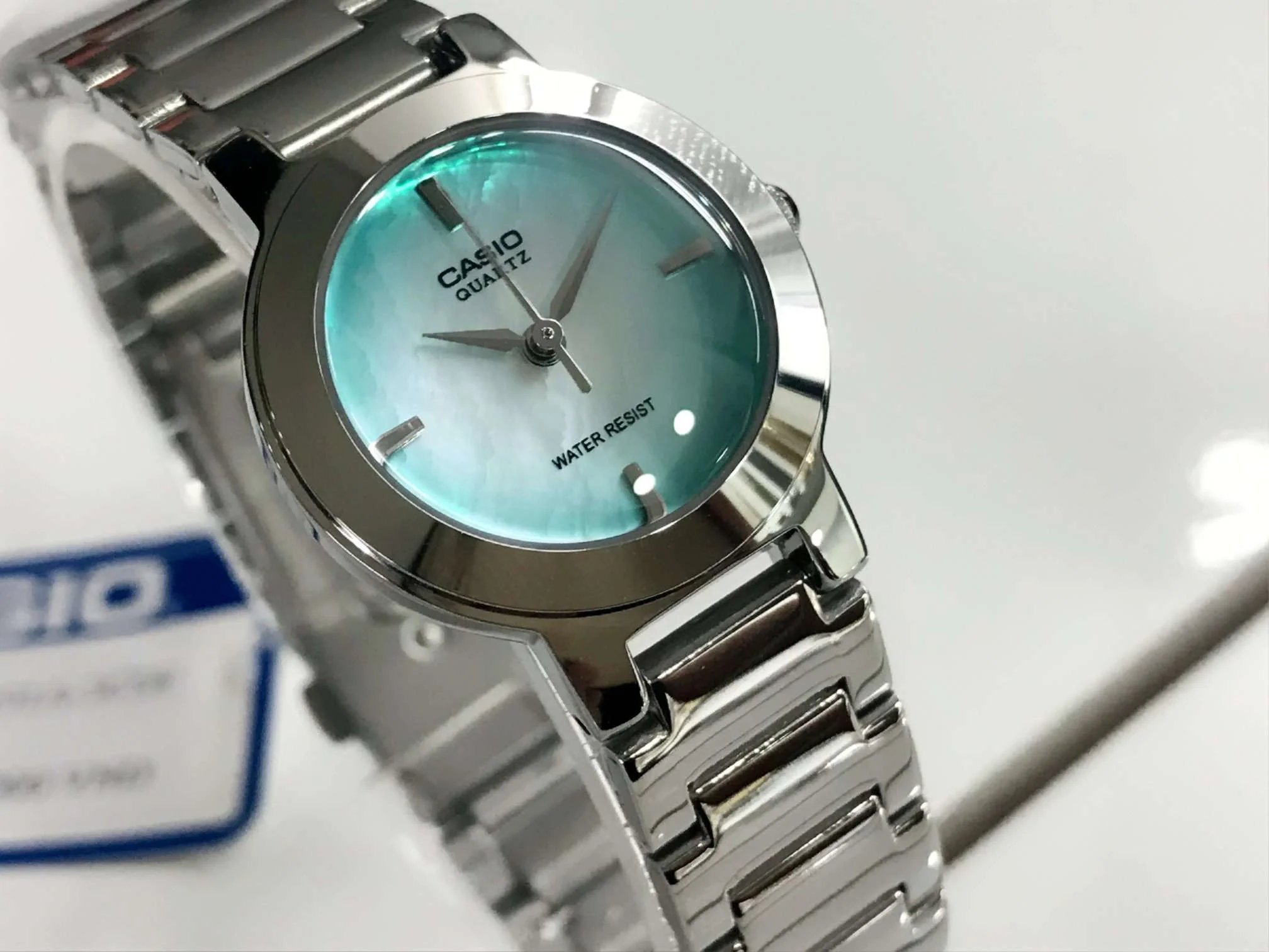 Close-up of olive green dial and silver stainless steel band