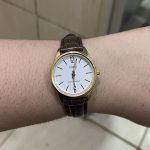 Close-up of gold-tone case and classic analog face