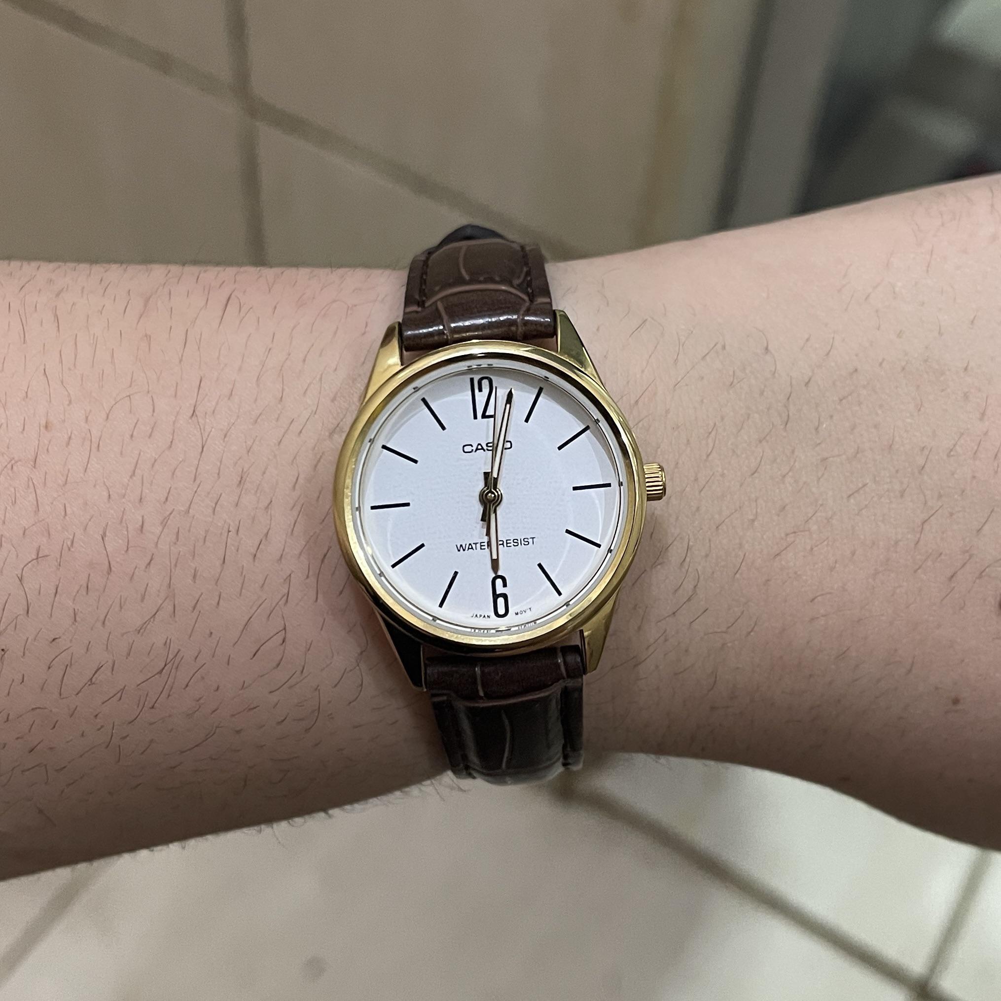 Close-up of gold-tone case and classic analog face
