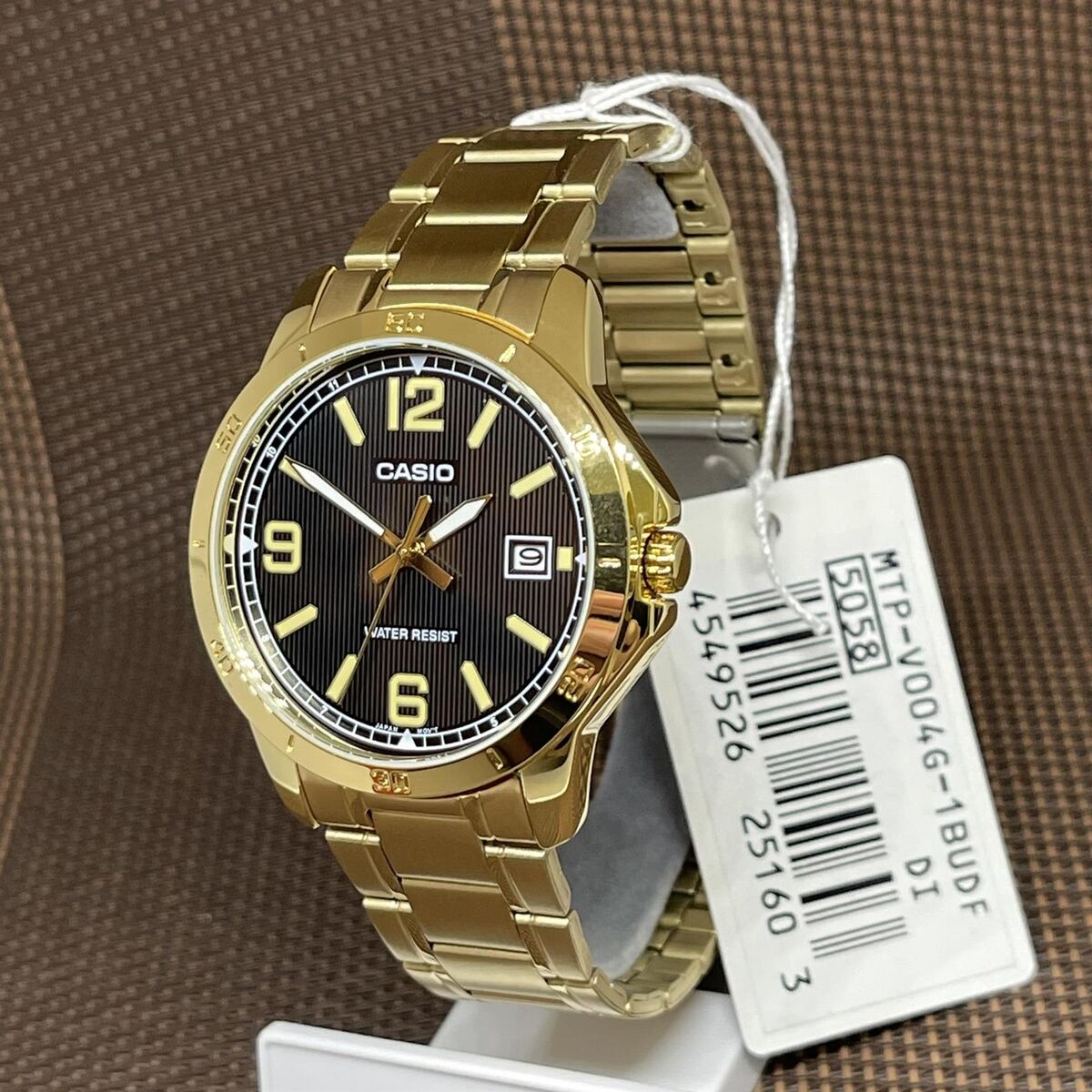 Close-up of black dial and date display on gold Casio watch